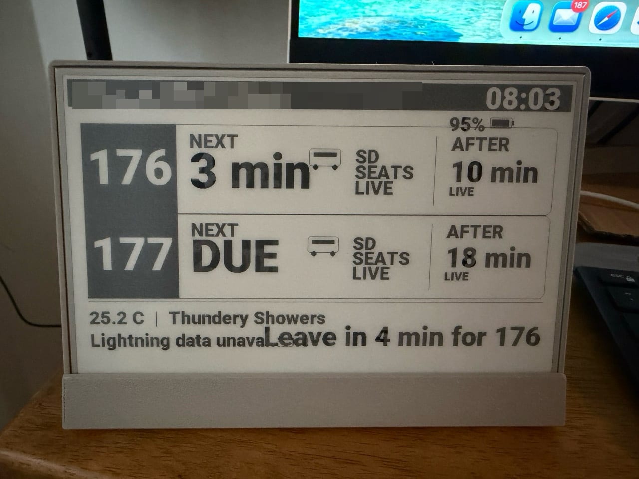 The screen showing bold black-and-grey blocks for services 176 and 177, a large 3 min and DUE, and a weather line where the leave-now message overlaps the lightning text