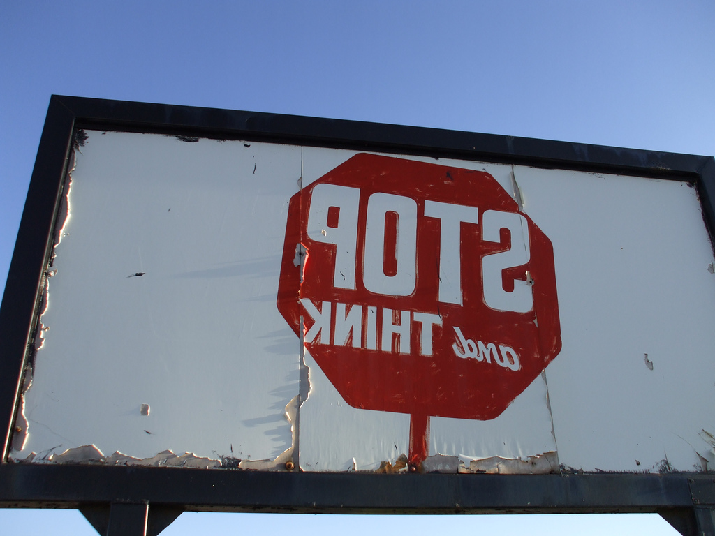 A mirrored, weathered stop sign.