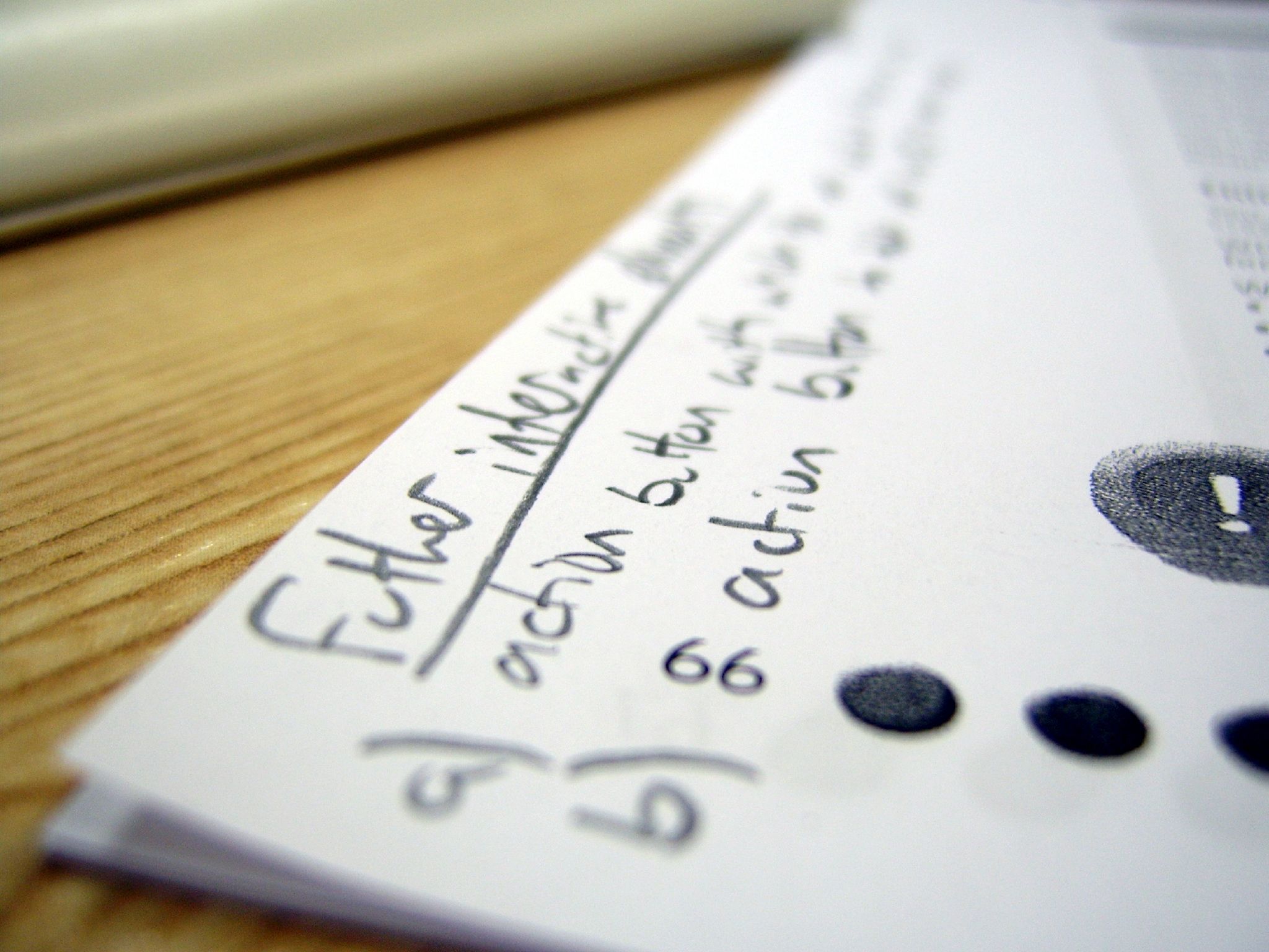 A piece of paper photographed up close. Most of the writing is out of focus.
